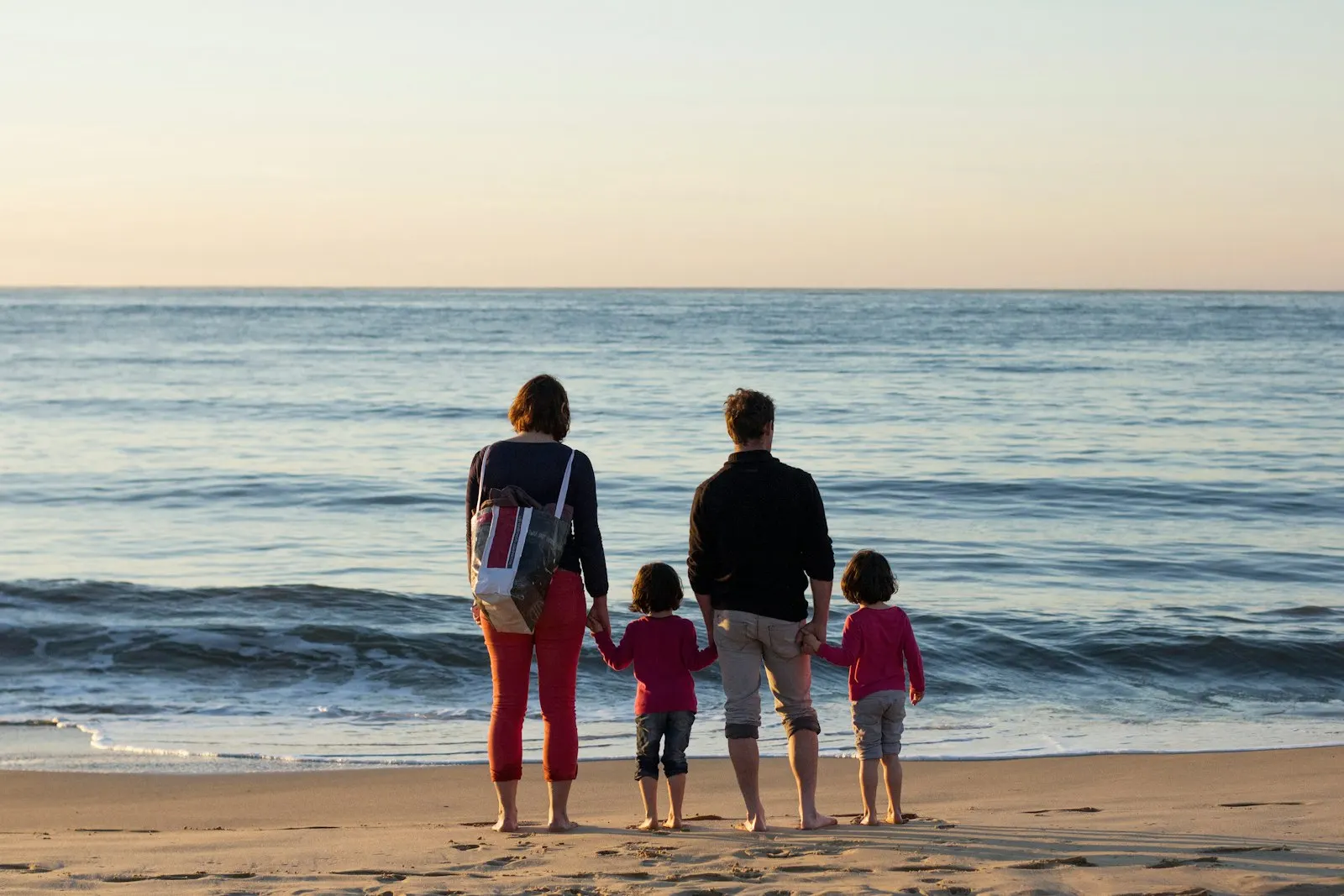 Family of four standing at the seashore