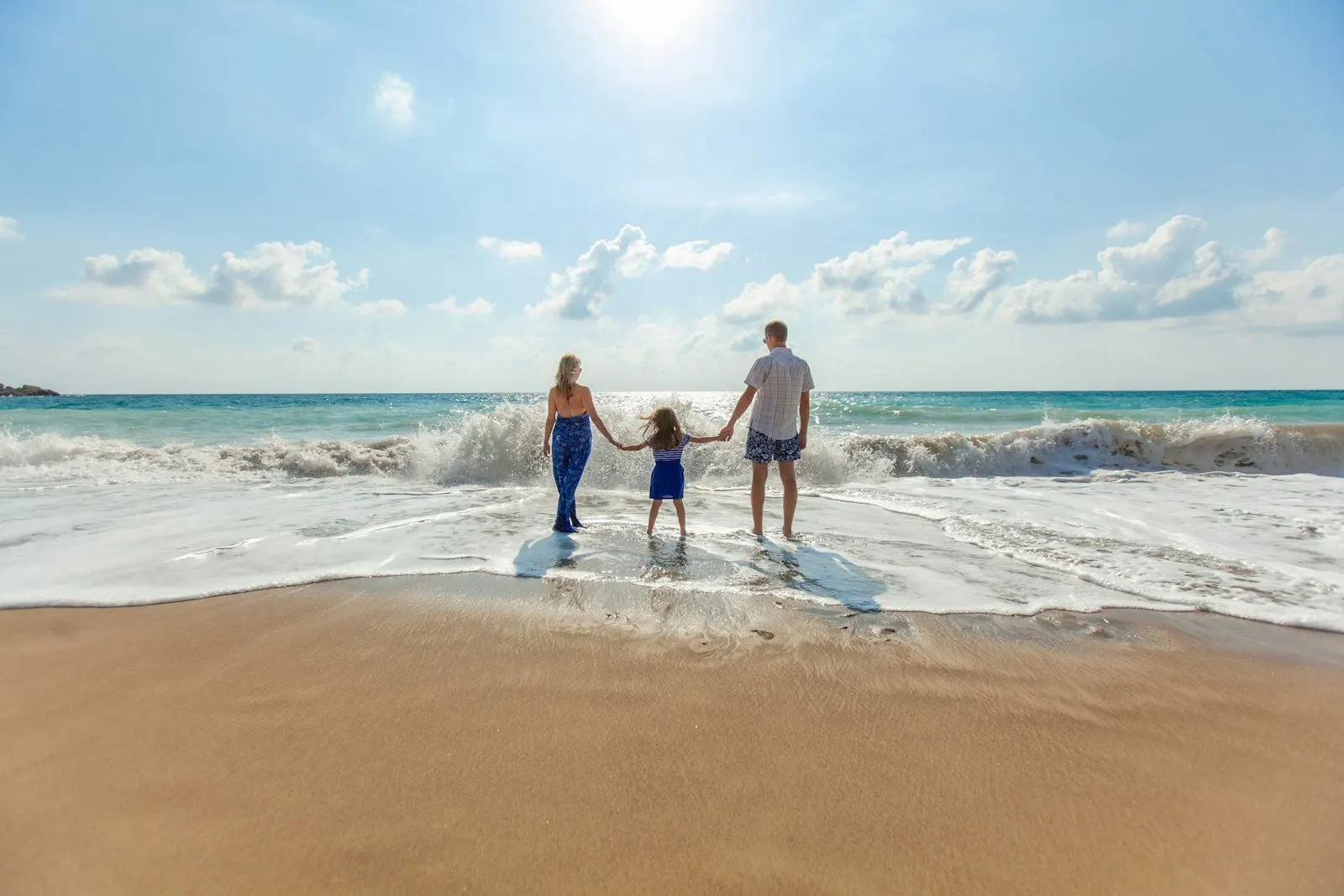 Family holding hands at the water's edge