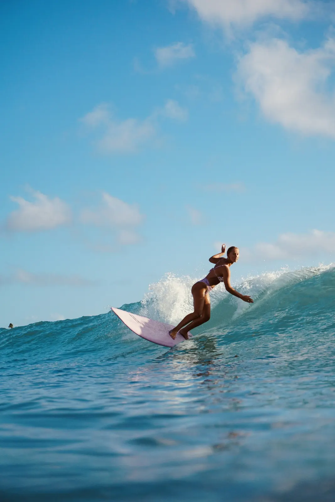 Woman surfing a blue wave
